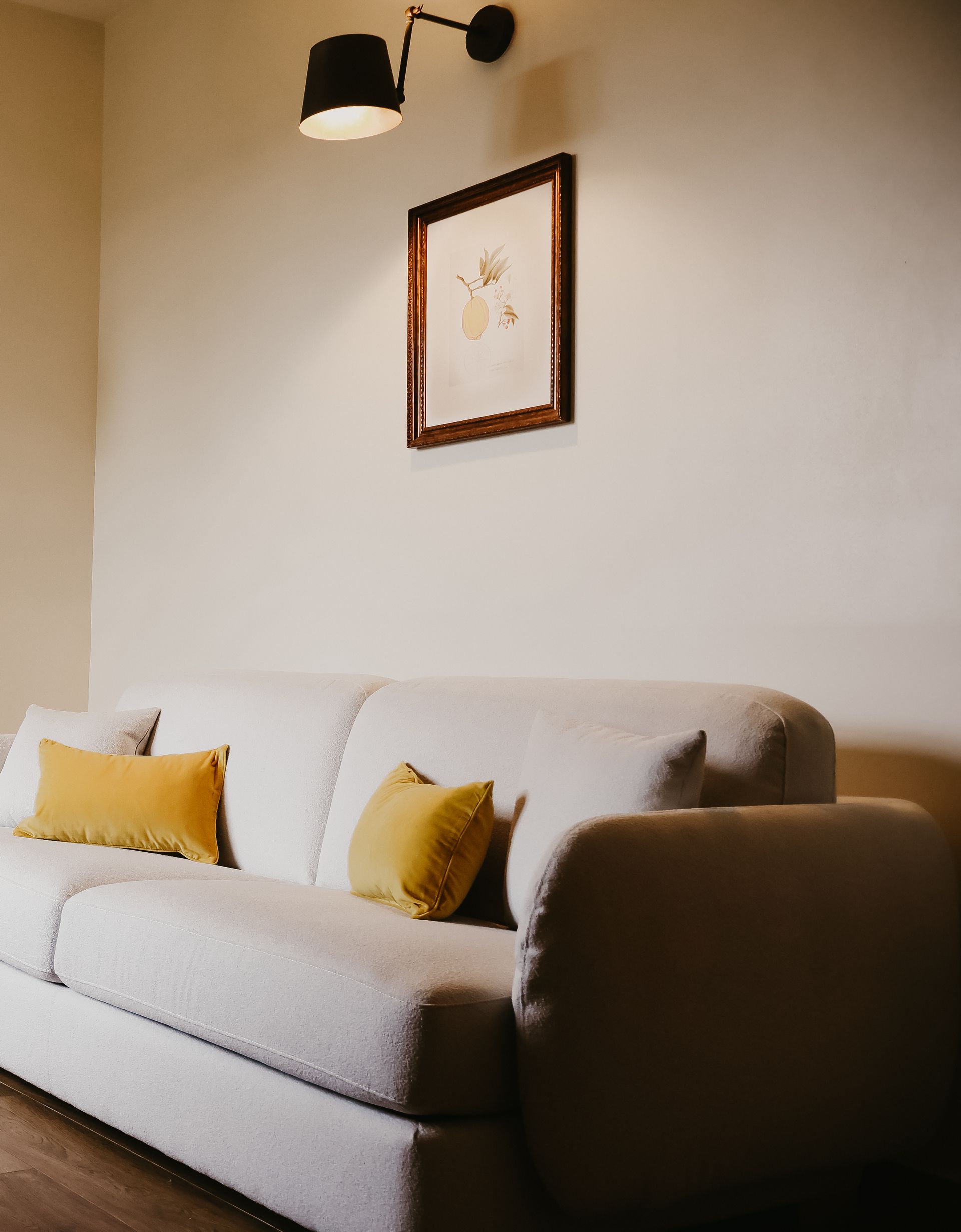 A living room with a couch and a picture on the wall