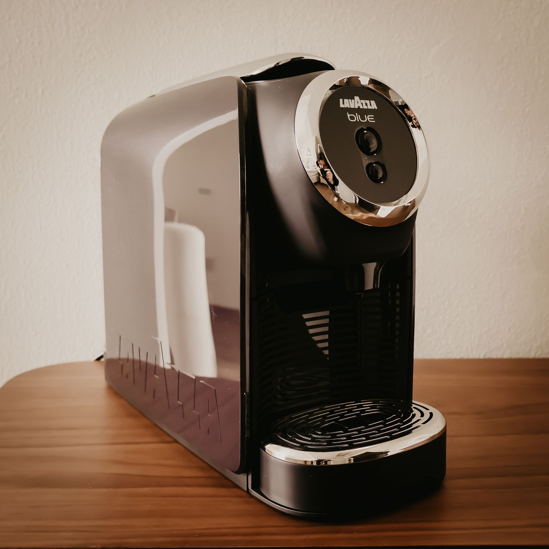 A lavazza coffee maker sits on a wooden table