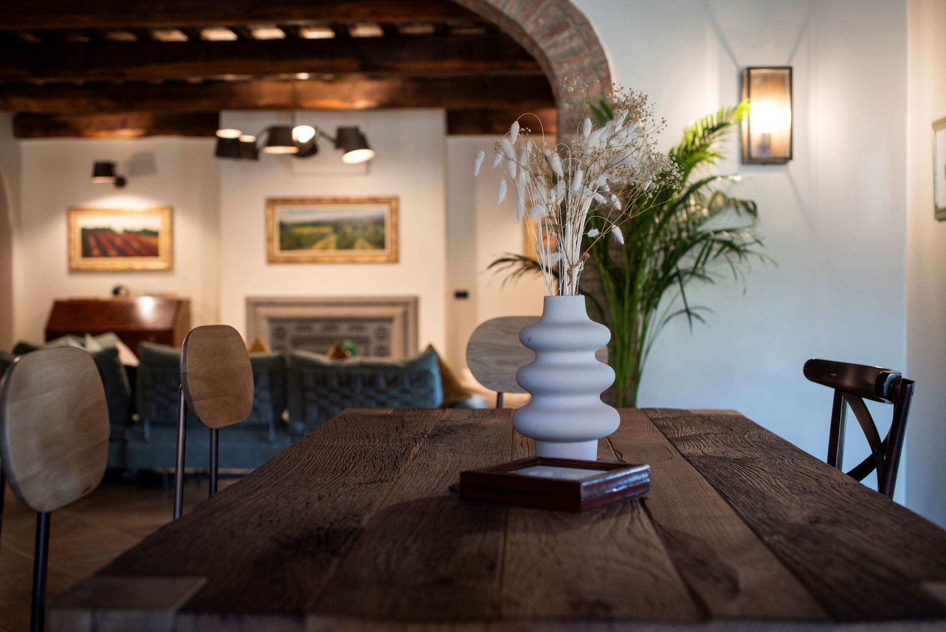 A wooden table with a vase of flowers on it in a living room.
