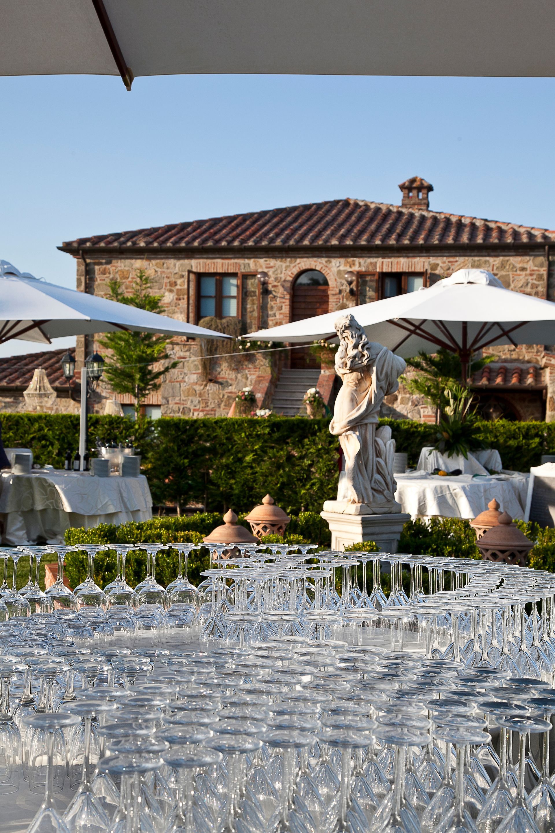 A lot of wine glasses are lined up in front of a house