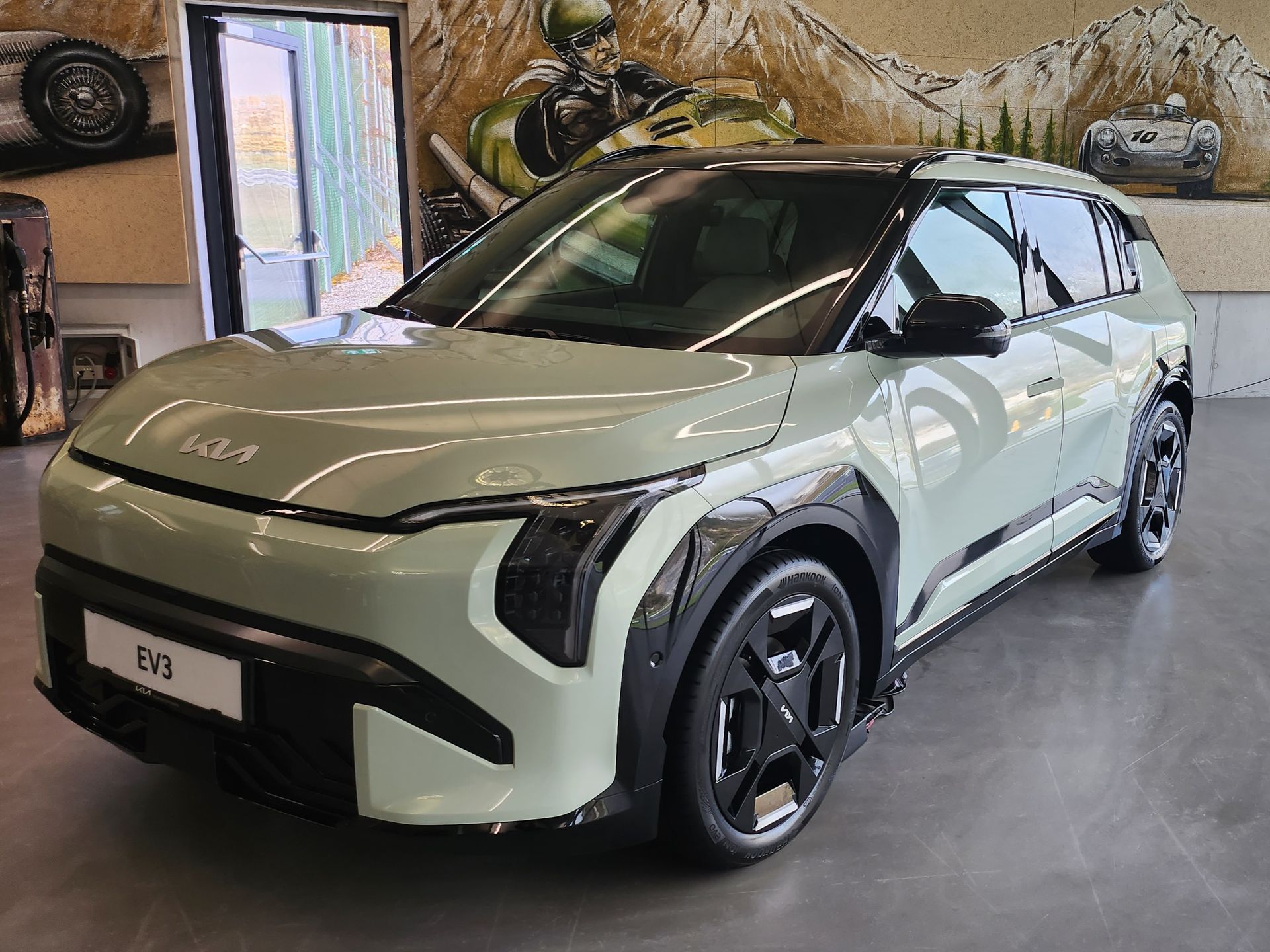 Ein grüner KIA EV 3 Auto steht in einem Ausstellungsraum.