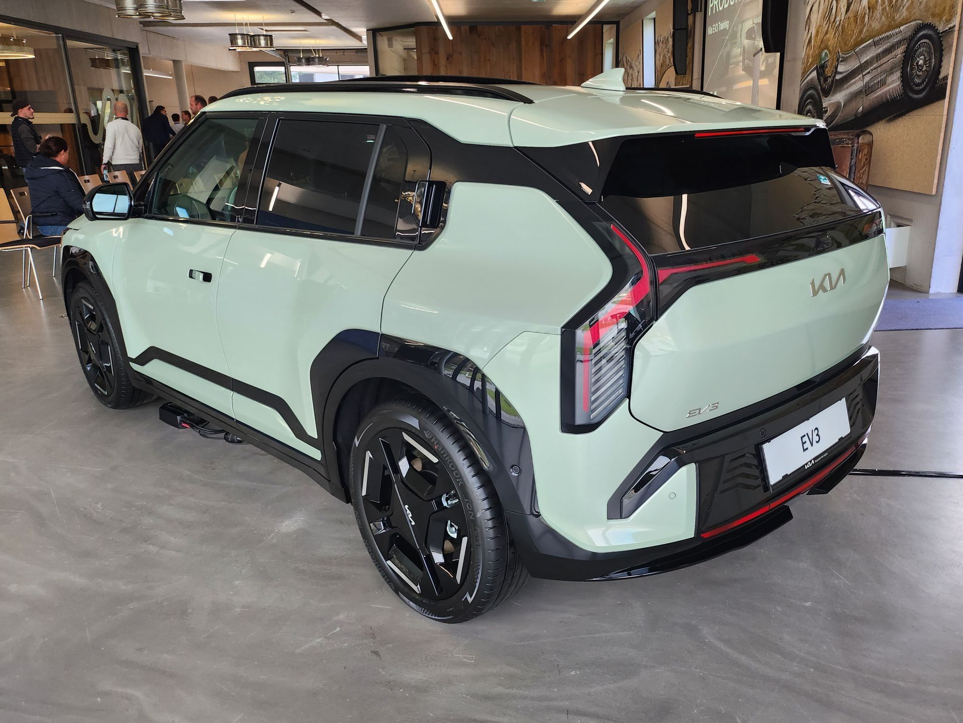 Ein grüner KIA EV 3 Auto steht in einem Ausstellungsraum.