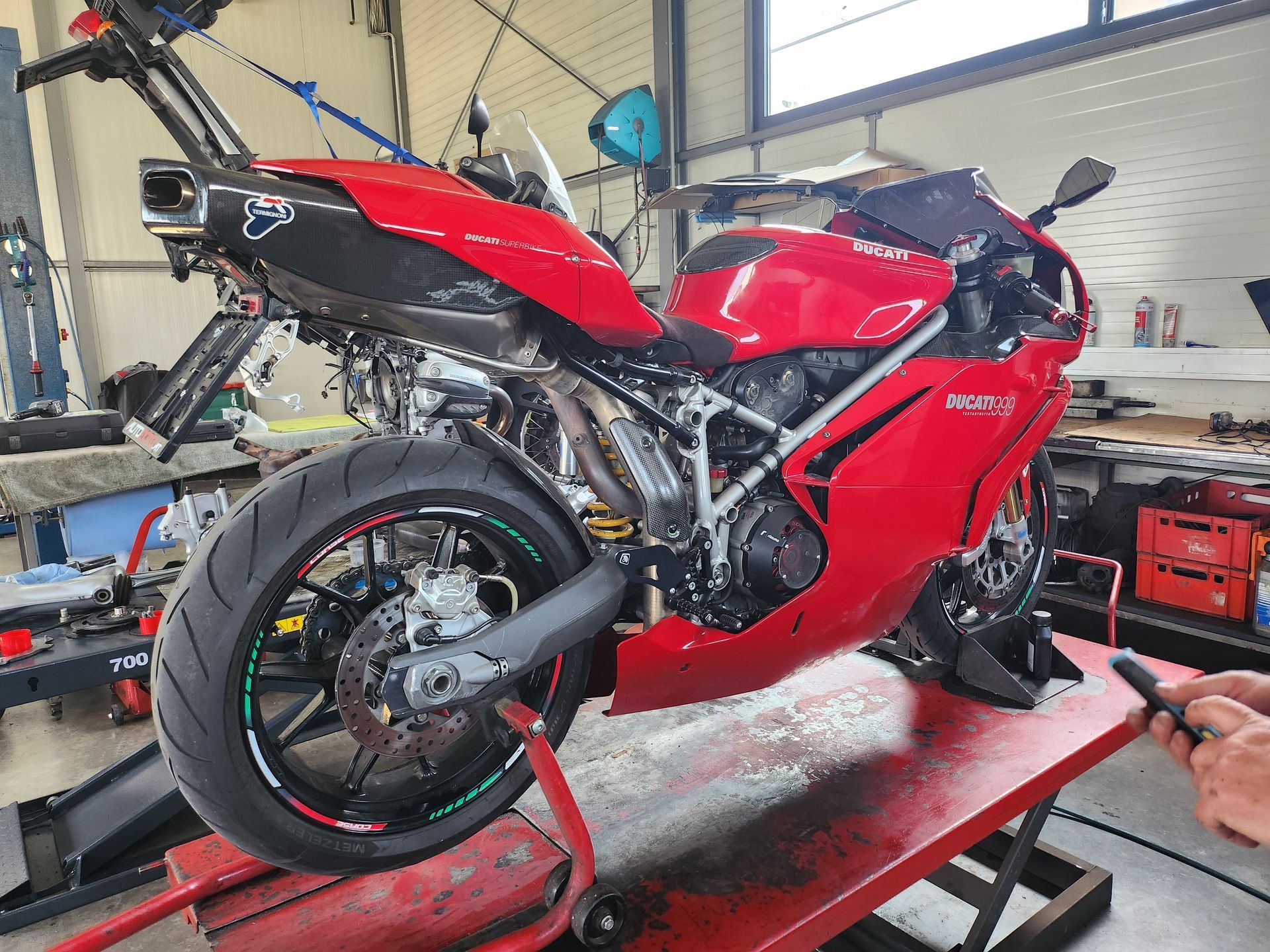 Ein rotes Ducati 999 Motorrad steht auf einer Hebebühne in einer Garage.