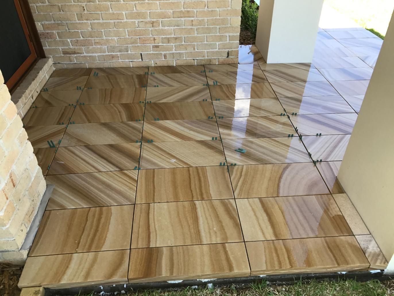 A Tiled Floor With A Brick Wall In The Background — Lewis Landscapes In Yippin Creek, NSW