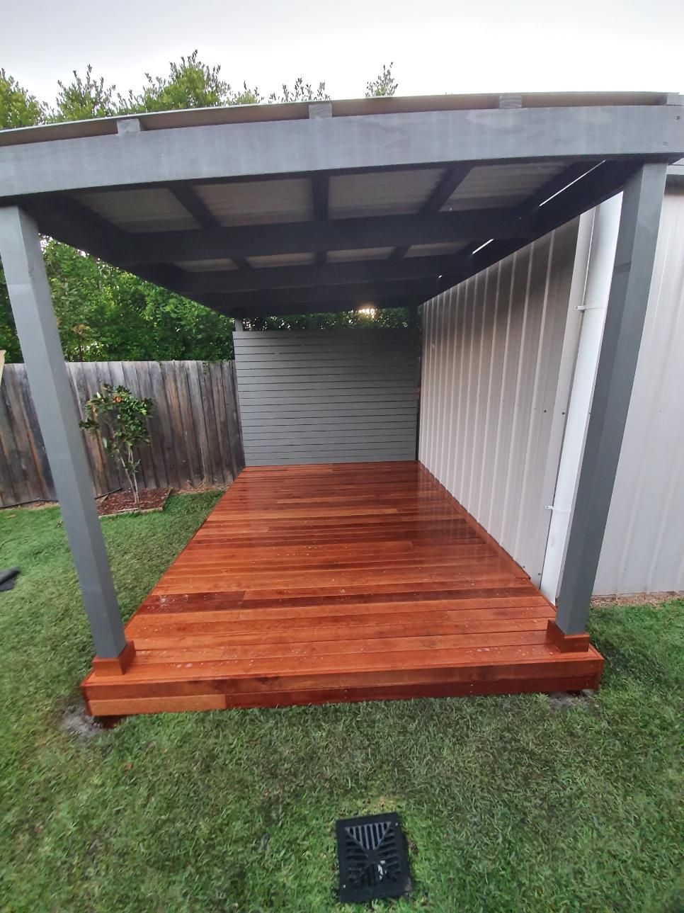 A Wooden Deck Under A Pergola In A Backyard — Lewis Landscapes In Yippin Creek, NSW