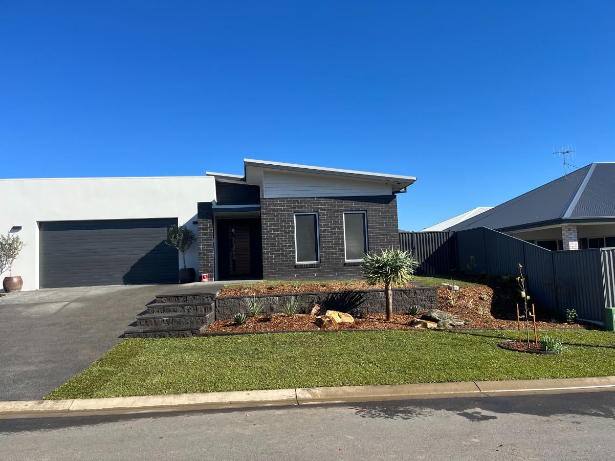 A House With A Lot Of Grass In Front Of It And A Garage — Lewis Landscapes In Yippin Creek, NSW