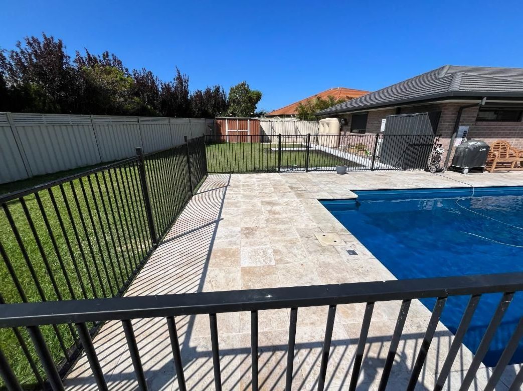 A Fence Surrounds A Large Swimming Pool In A Backyard — Lewis Landscapes In Yippin Creek, NSW