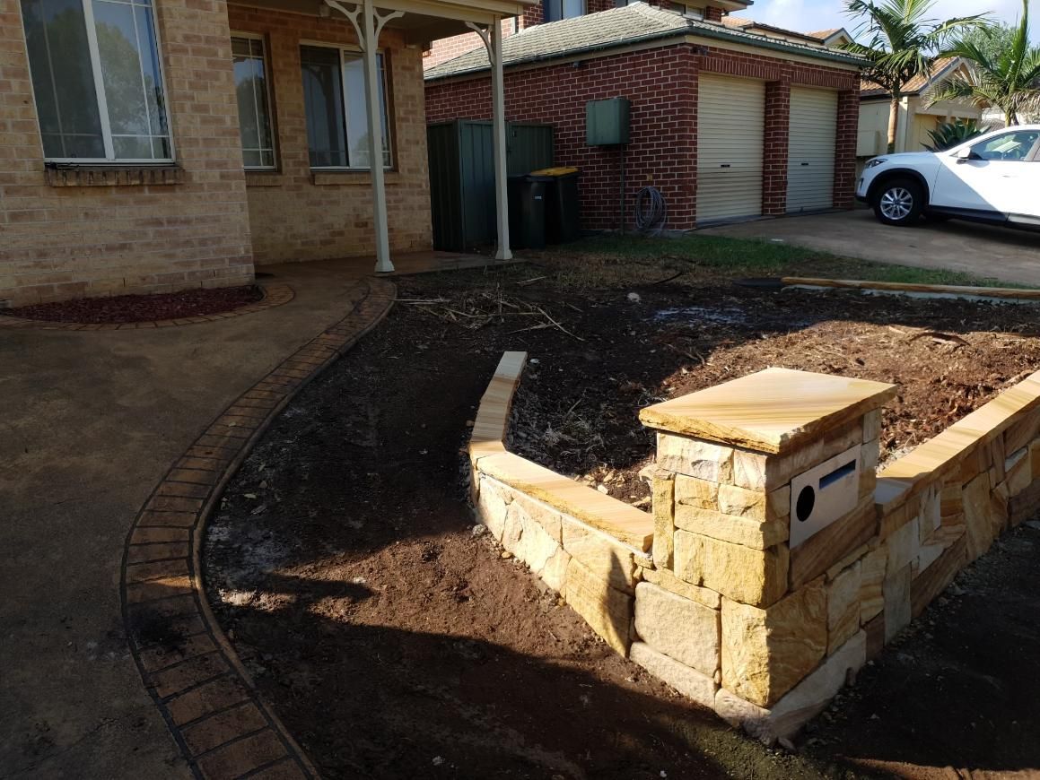 A White Car Is Parked In Front Of A Brick House — Lewis Landscapes In Yippin Creek, NSW