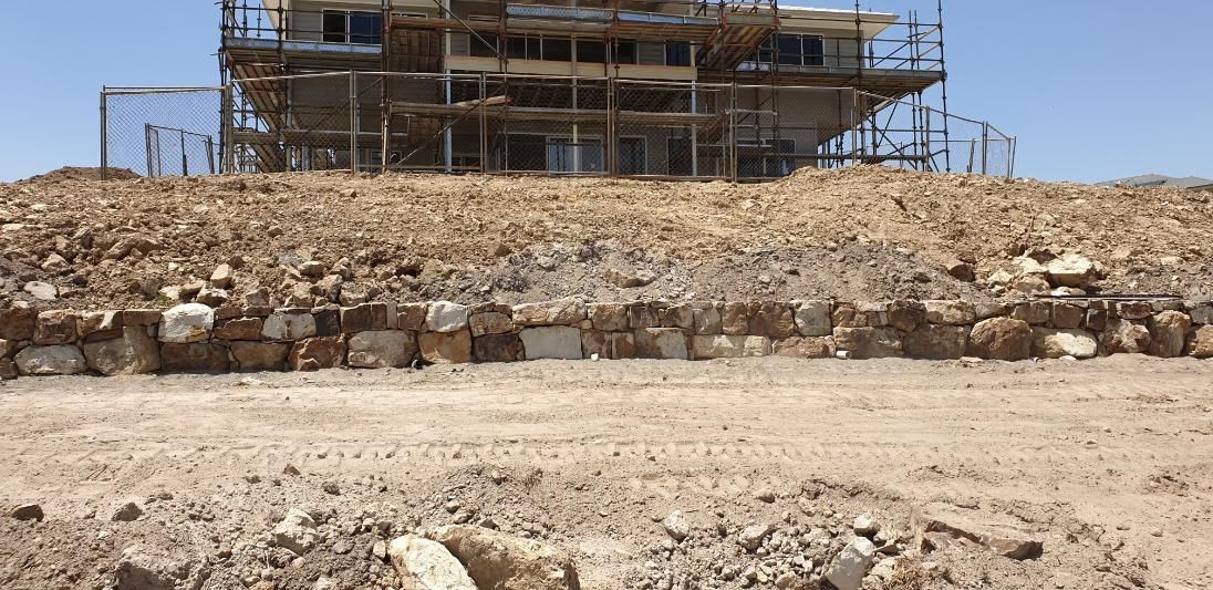 A Large Building Is Being Built On Top Of A Hill — Lewis Landscapes In Port Macquarie, NSW