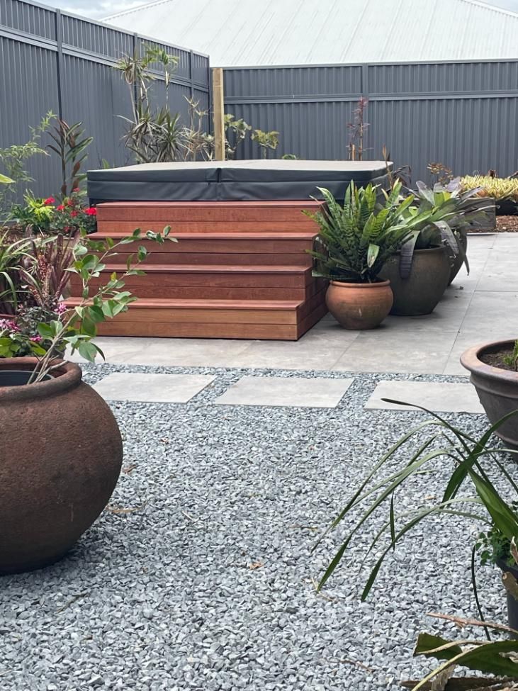 A Backyard With A Hot Tub And Potted Plants — Lewis Landscapes In Yippin Creek, NSW