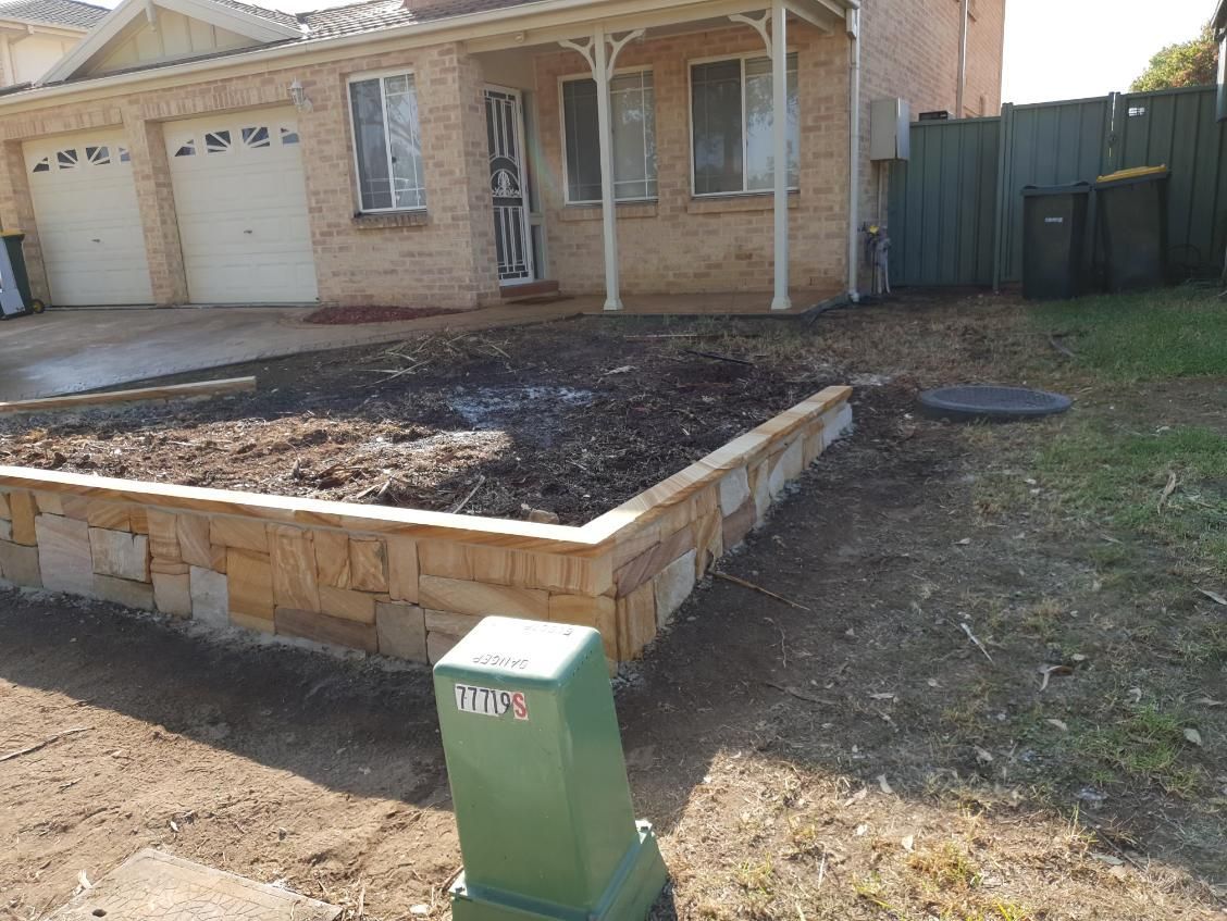 A Brick House With A Green Mailbox In Front Of It — Lewis Landscapes In Yippin Creek, NSW
