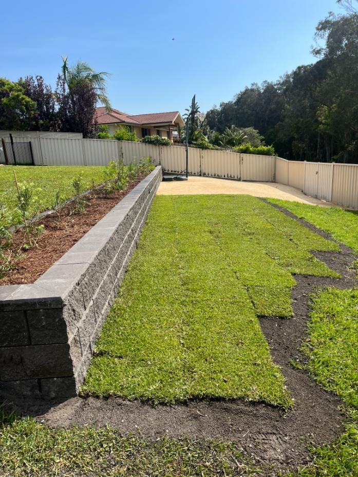 A Lush Green Lawn With A Brick Wall And A Fence In The Background — Lewis Landscapes In Yippin Creek, NSW
