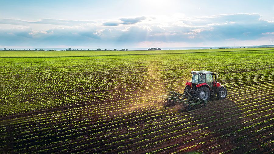 An aerial view of a tractor plowing a field.