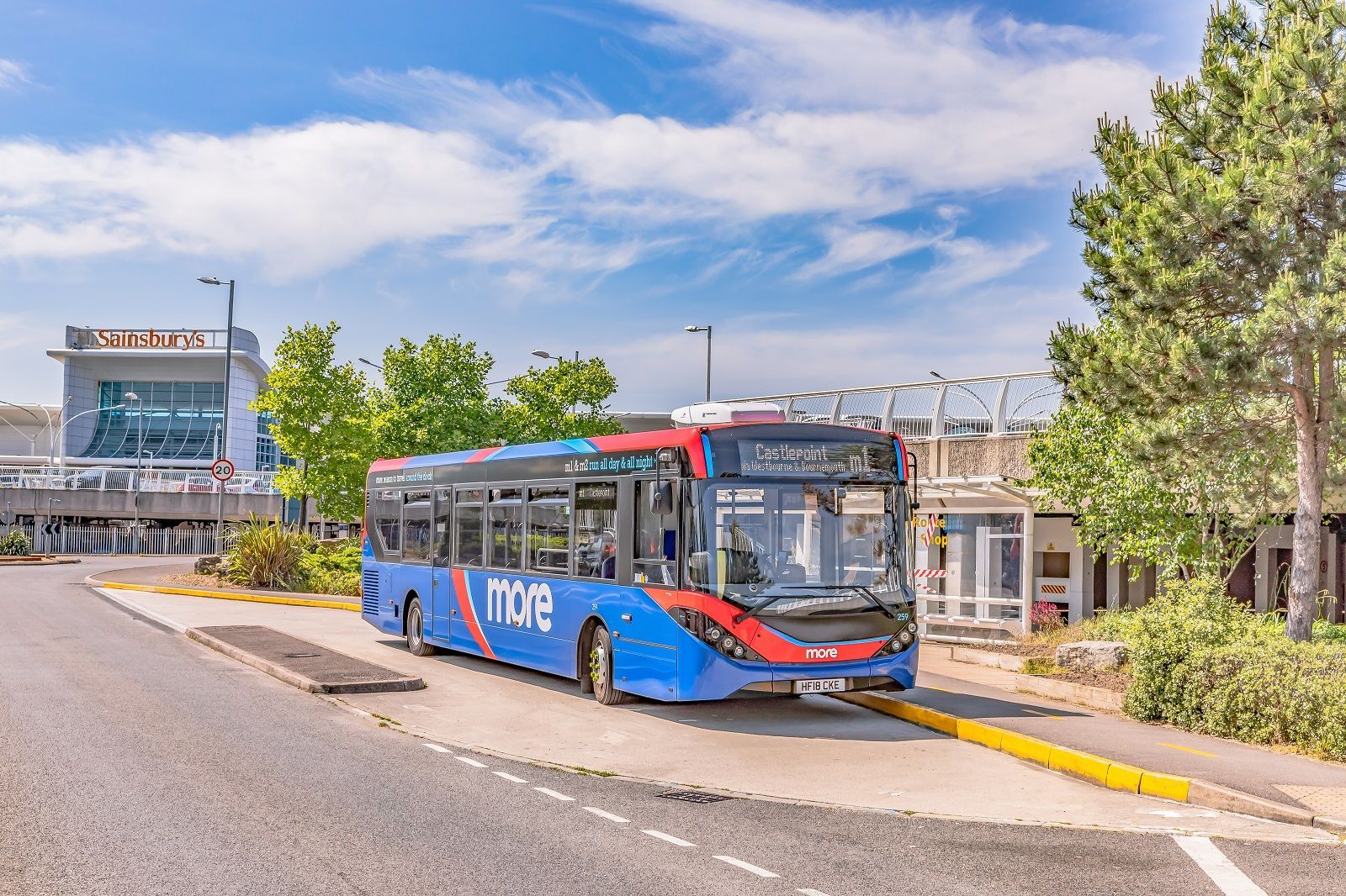 A blue and red bus is parked on the side of the road.