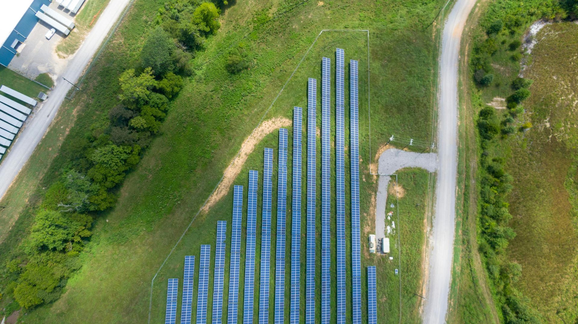 An aerial view of a row of solar panels in a field.