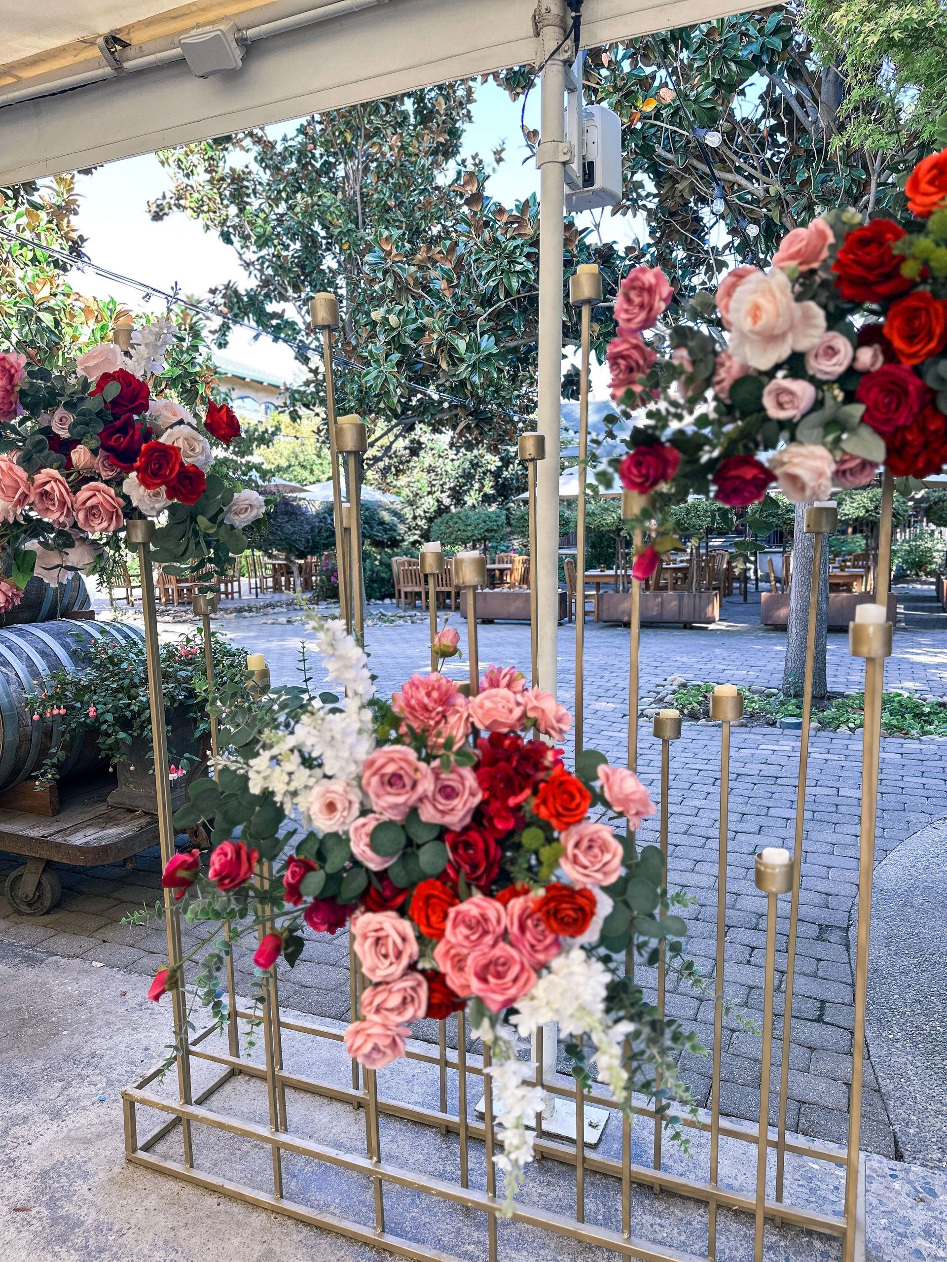 Floral arrangement on a golden metal frame with red and pink roses outside.