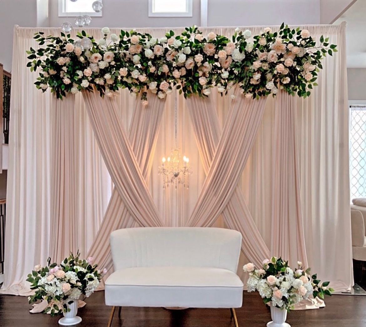 there is a chair in front of draping with flowers on it .