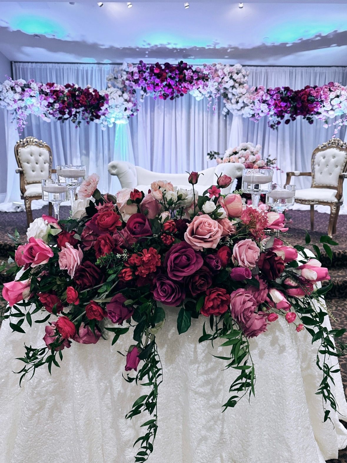 a sweetheart table with a bunch of flowers on it in a room .
