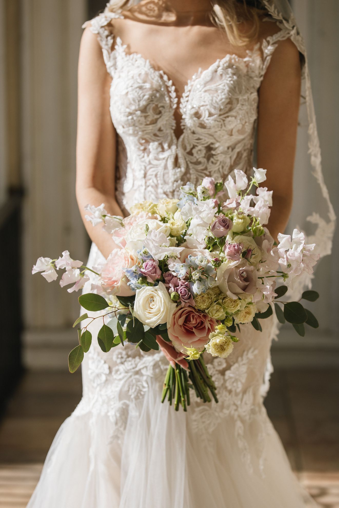 A bride in a wedding dress is holding a bouquet of flowers.