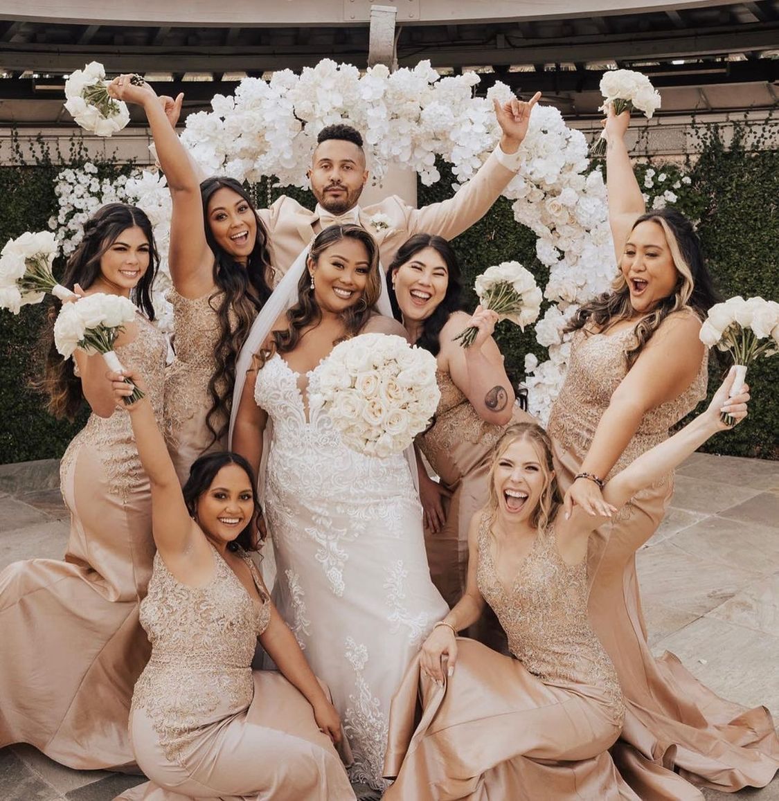 a bride and groom pose with their bridesmaids