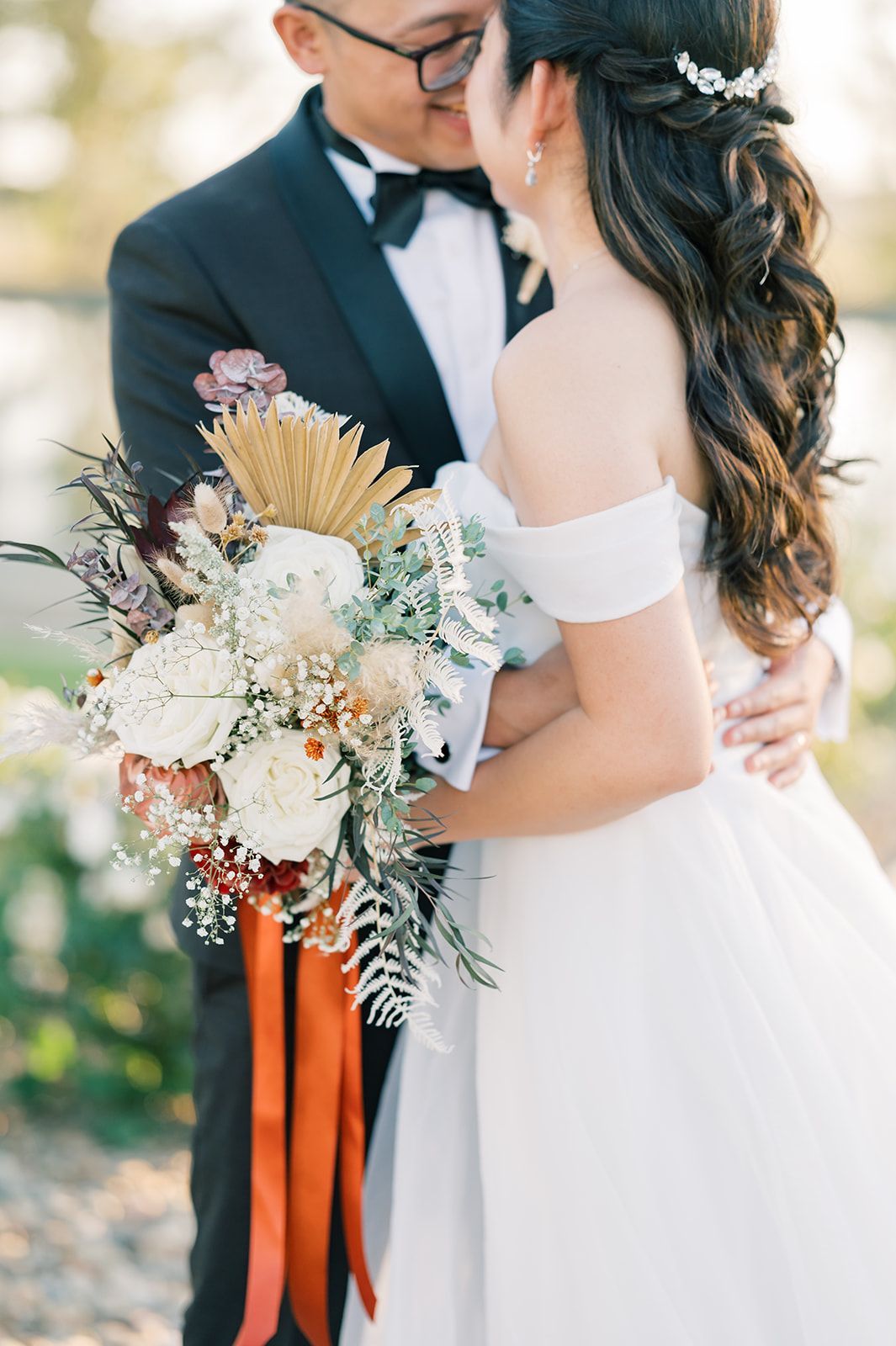 a bride and groom kissing while the bride holds a bouquet of flowers