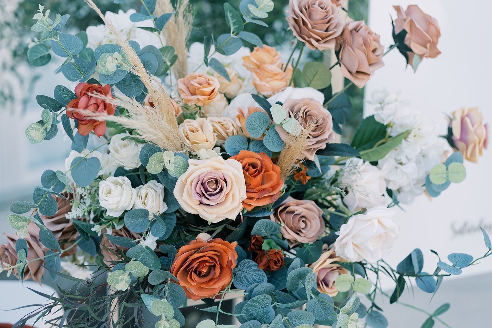 a large bouquet of flowers including roses and eucalyptus