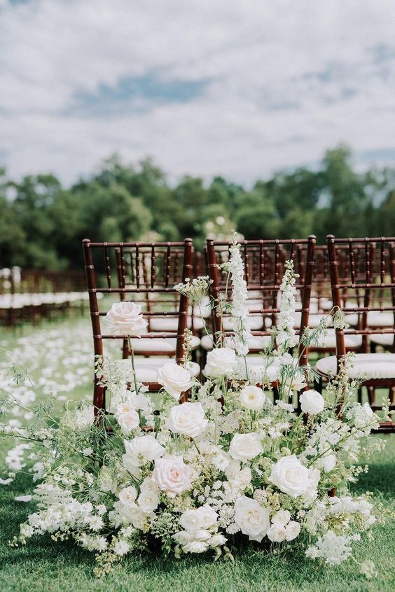 a row of chairs with white flowers in front of them