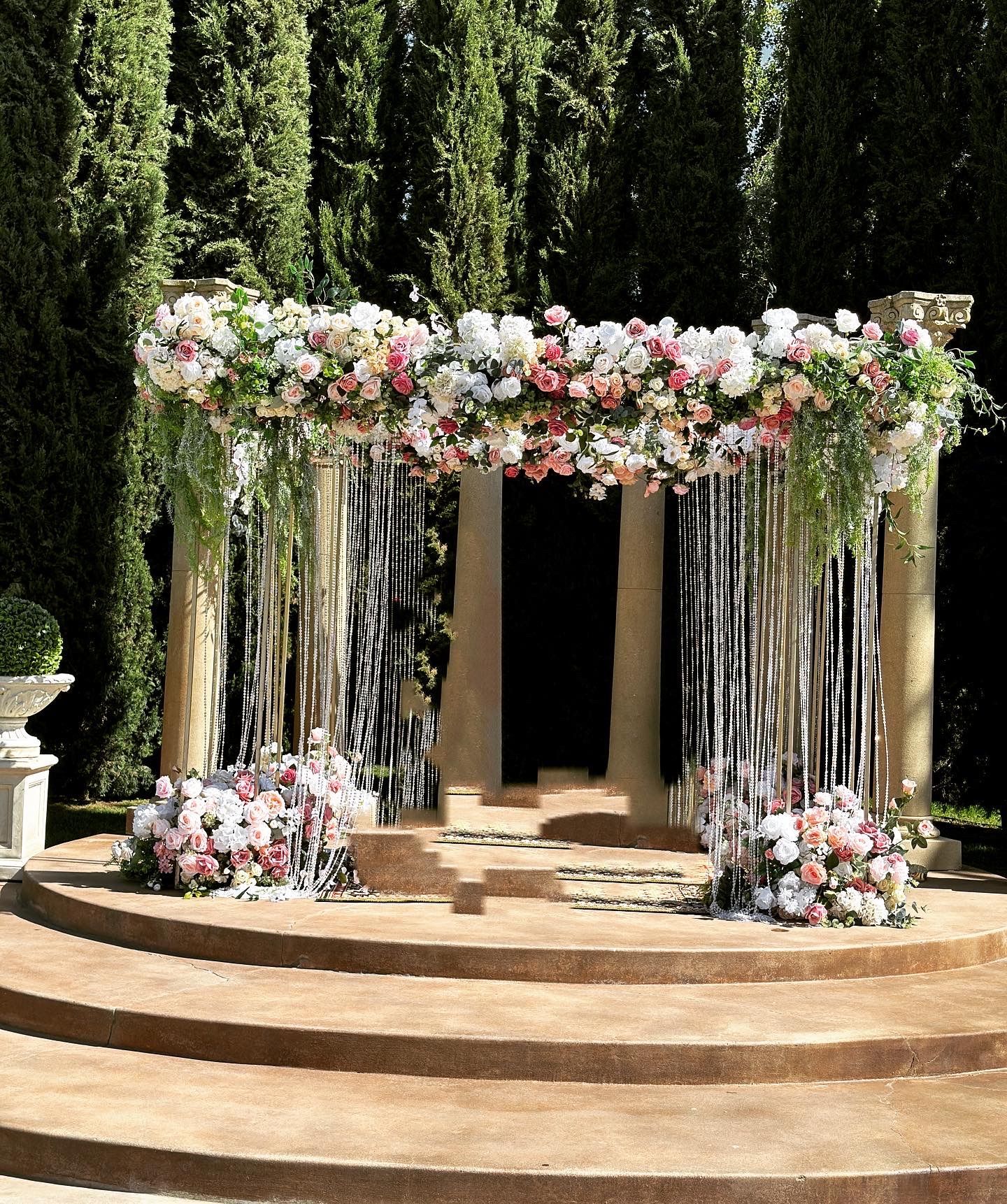 A stage decorated with flowers and ribbons for a wedding