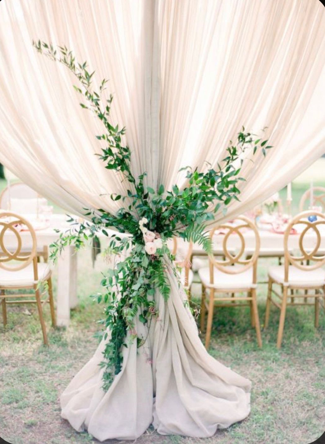 A table with a curtain and flowers on it