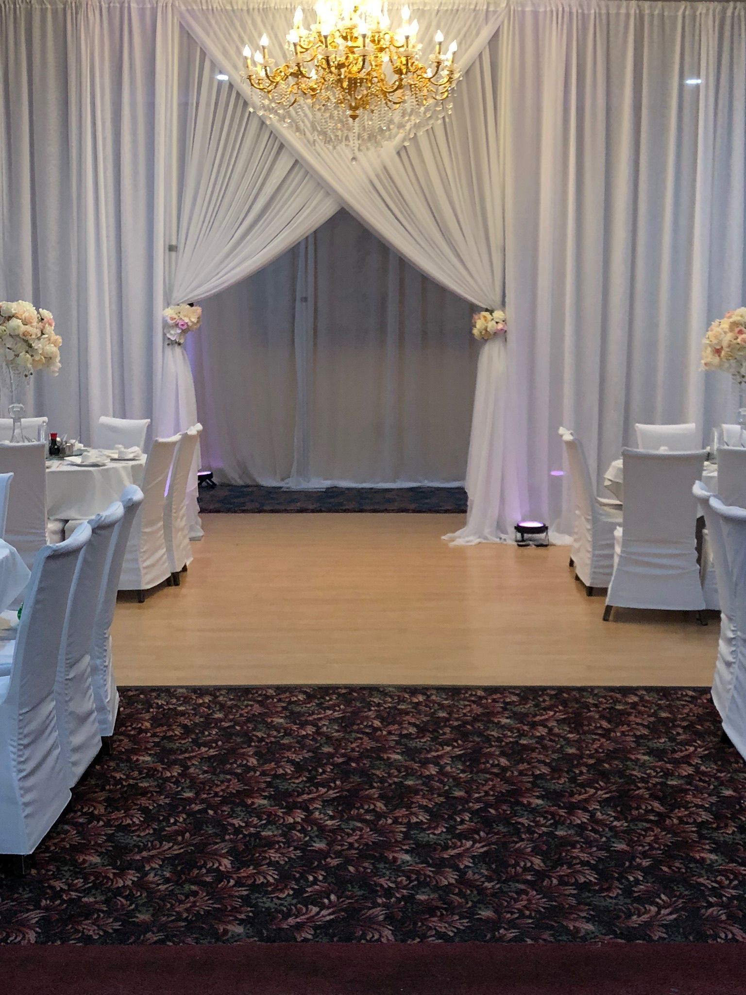 A room filled with tables and chairs and a chandelier.
