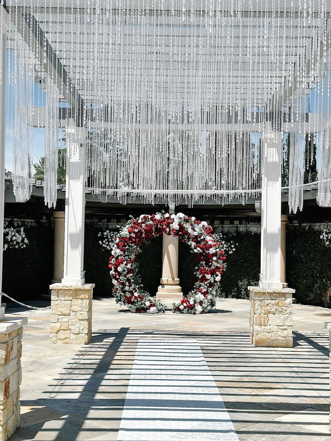 A wedding arch with flowers and crystals hanging from the ceiling.