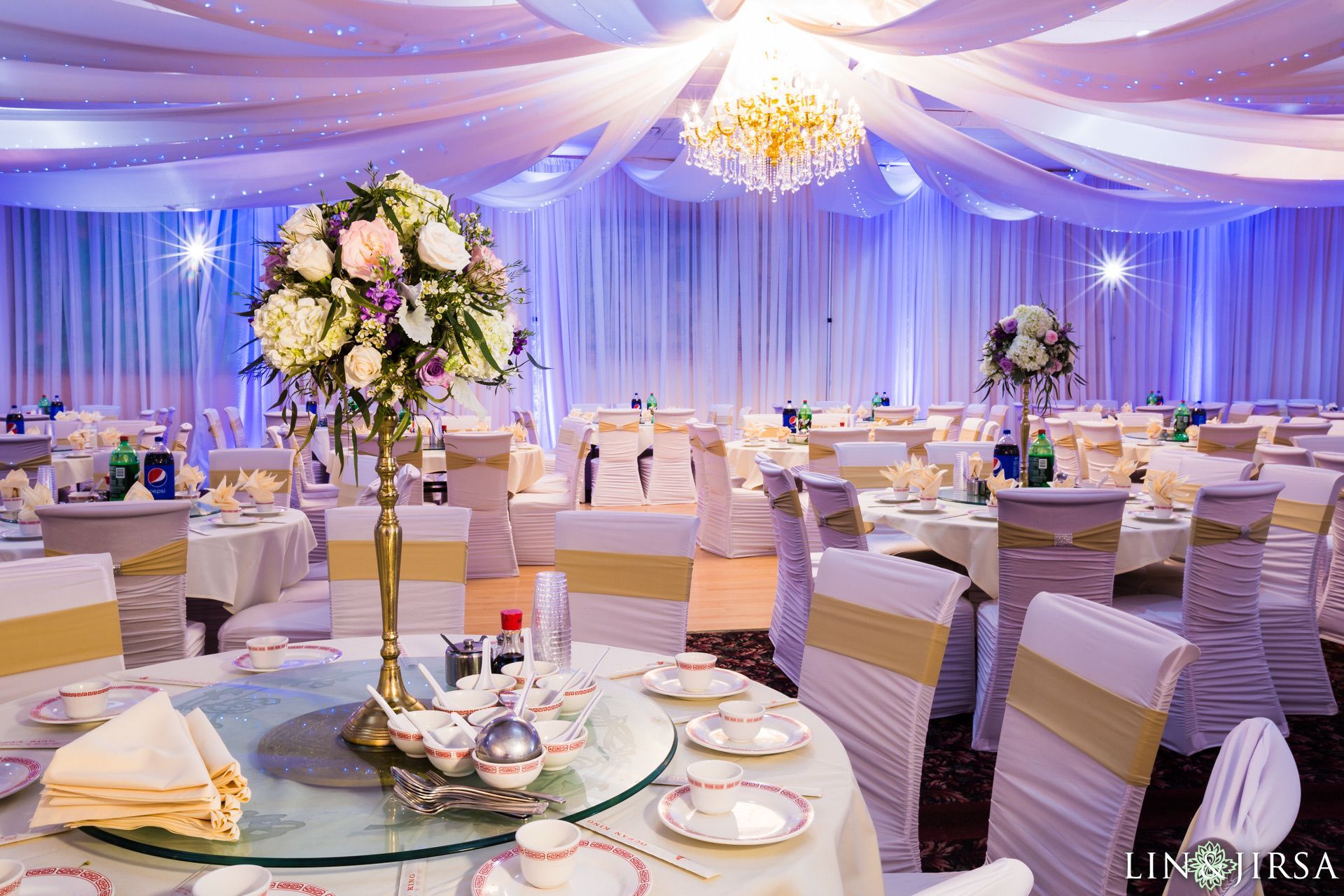 A large room with tables and chairs set up for a wedding reception.
