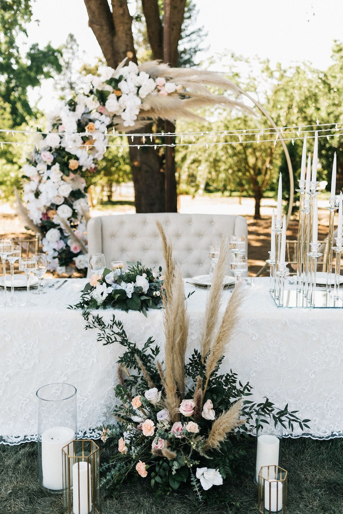 A long table with flowers and candles on it.