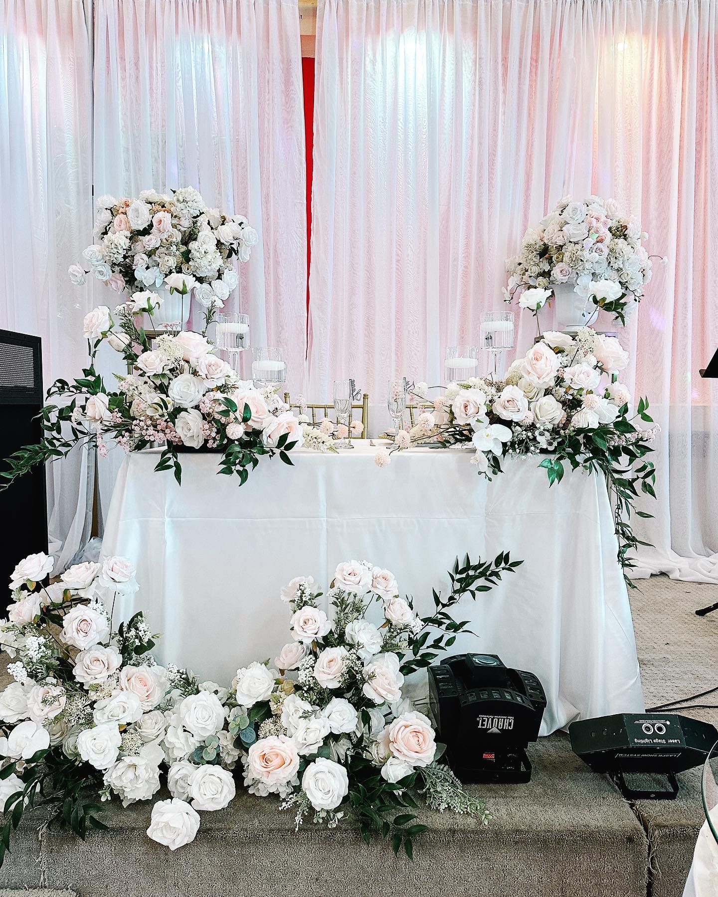 A table decorated with white flowers and candles for a wedding reception.