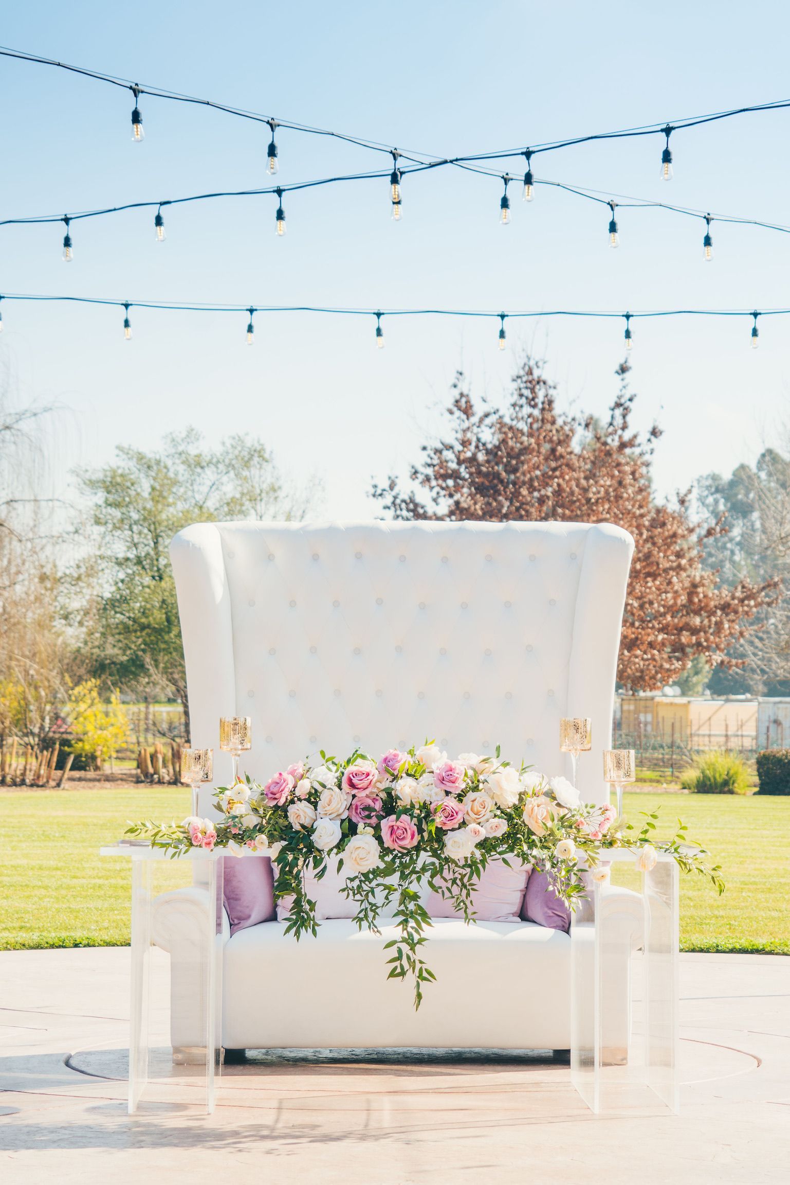 A white chair with flowers on it is sitting on a patio.