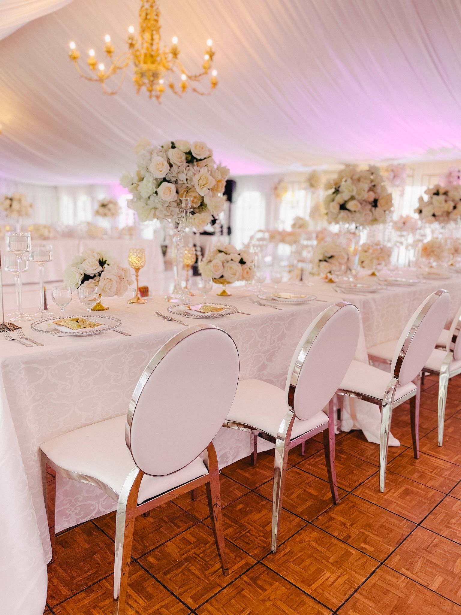 A large room with tables and chairs set up for a wedding reception.