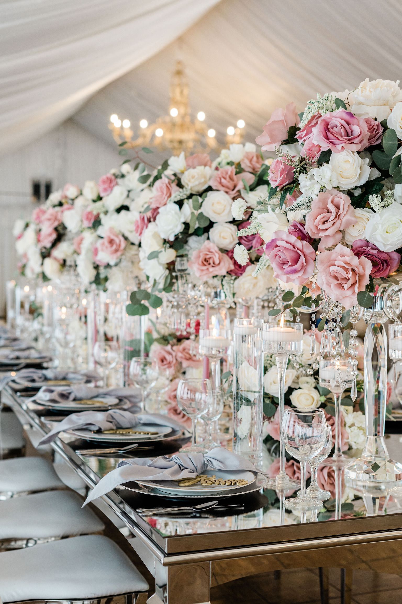 A long table with plates , candles , and flowers on it.