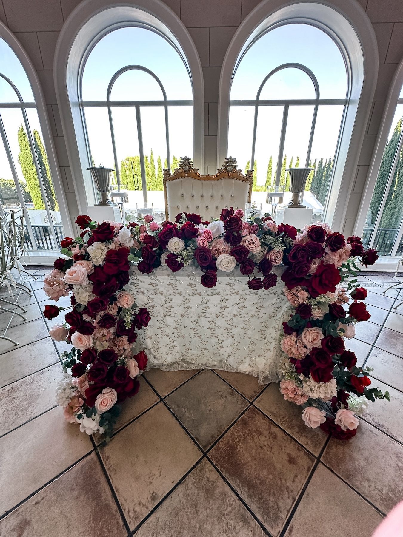 A table with a chair and flowers on it in a room.