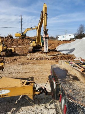 A construction site with a bulldozer and a hammer in the foreground