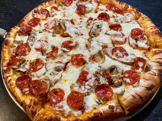A pepperoni pizza with mushrooms and cheese on a plate.