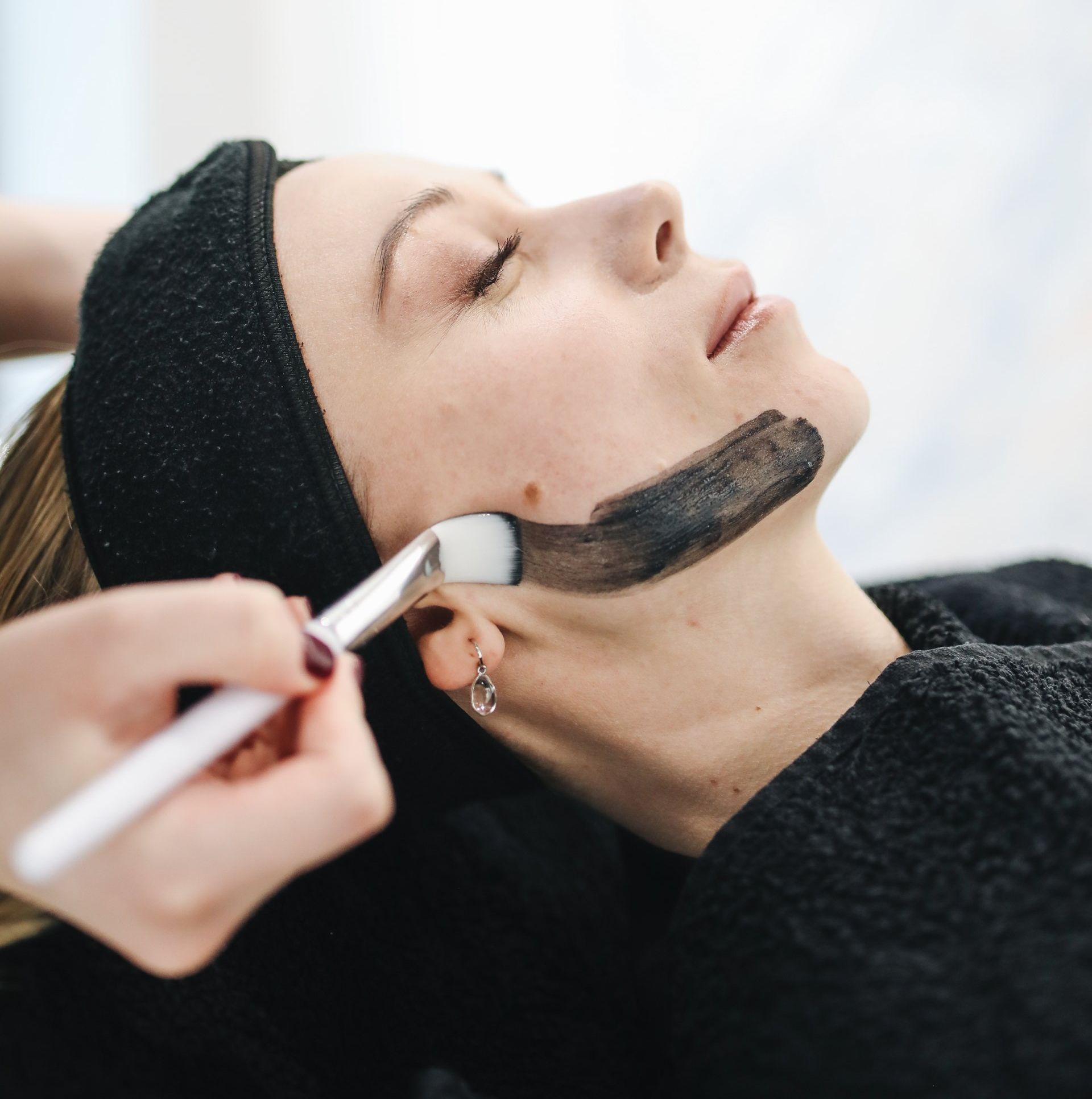 Een vrouw krijgt een gezichtsbehandeling met een borstel