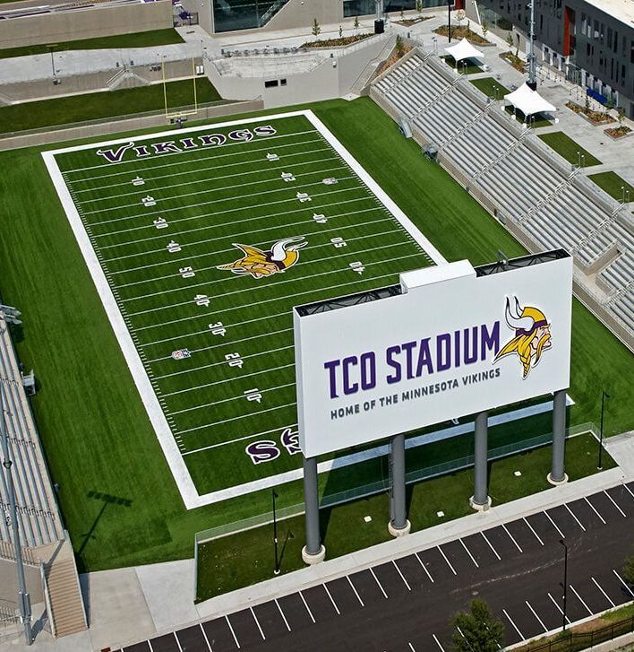 An aerial view of a football field with the letter m on it
