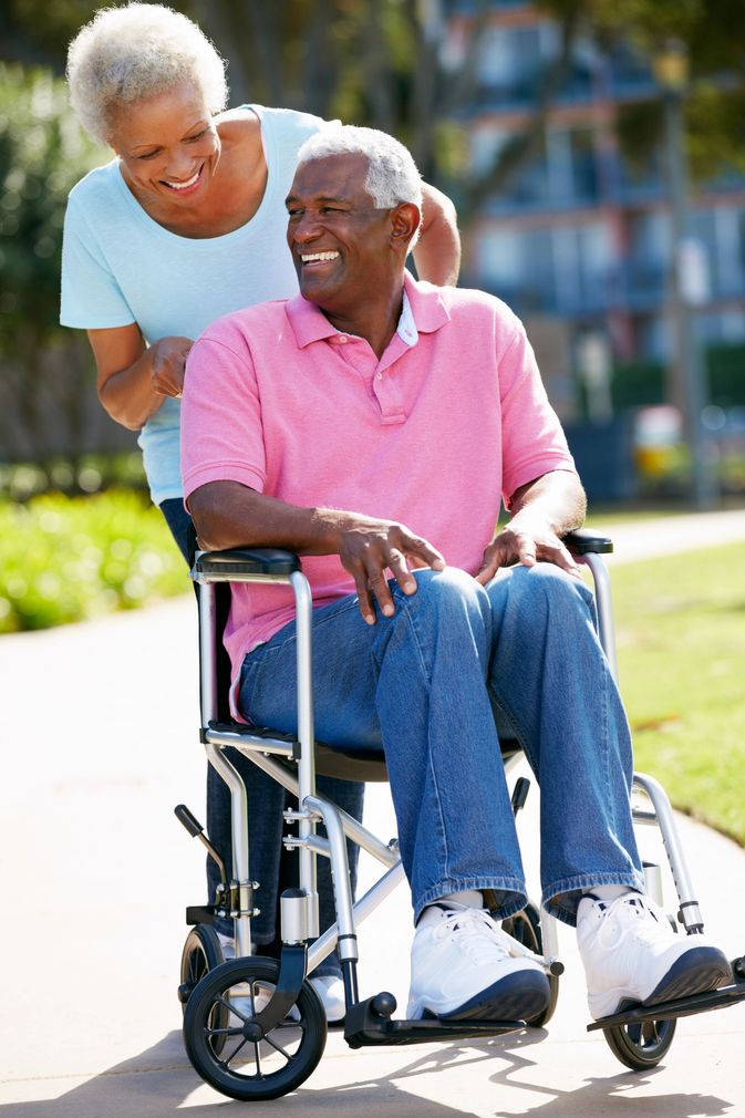 a man being pushed in a wheelchair by a woman
