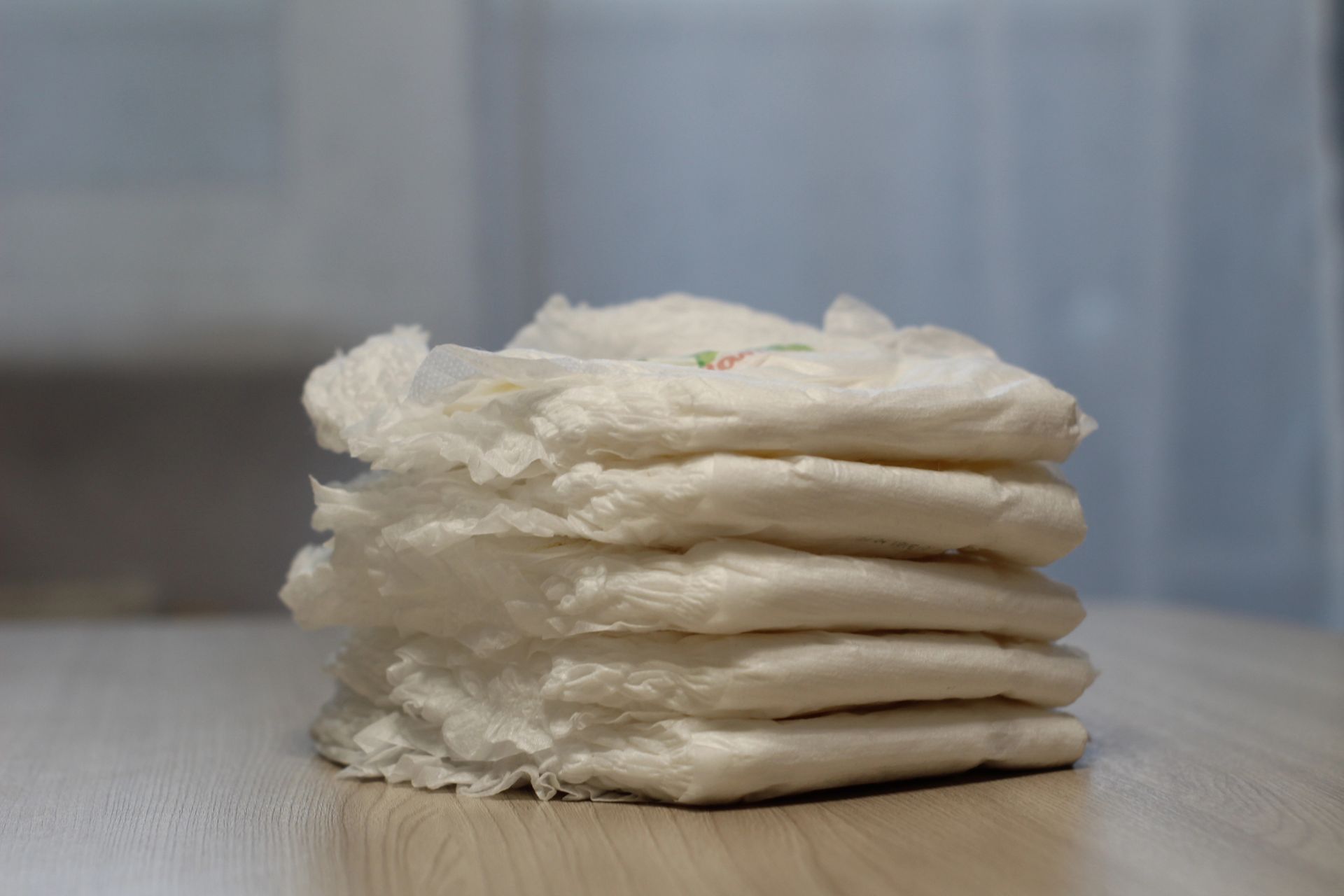 A stack of diapers sitting on top of a wooden table.