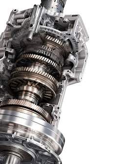 Close-up of a shiny metal automotive transmission gearbox with exposed gears and shafts.