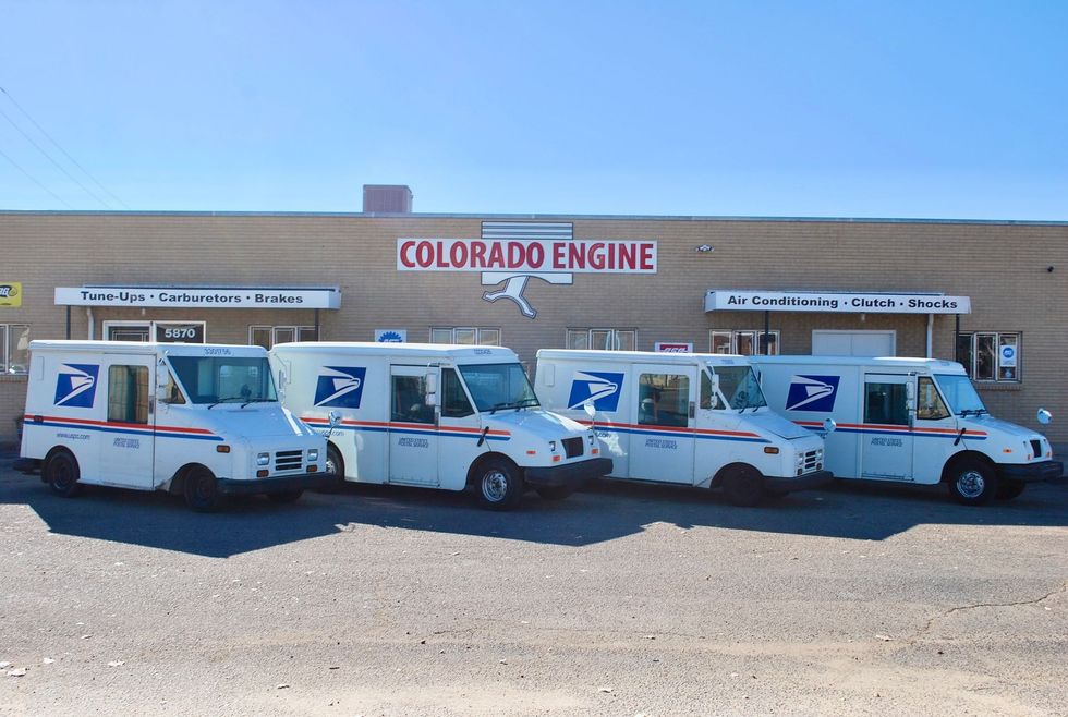 White pickup truck with hood open outside Colorado Engine shop