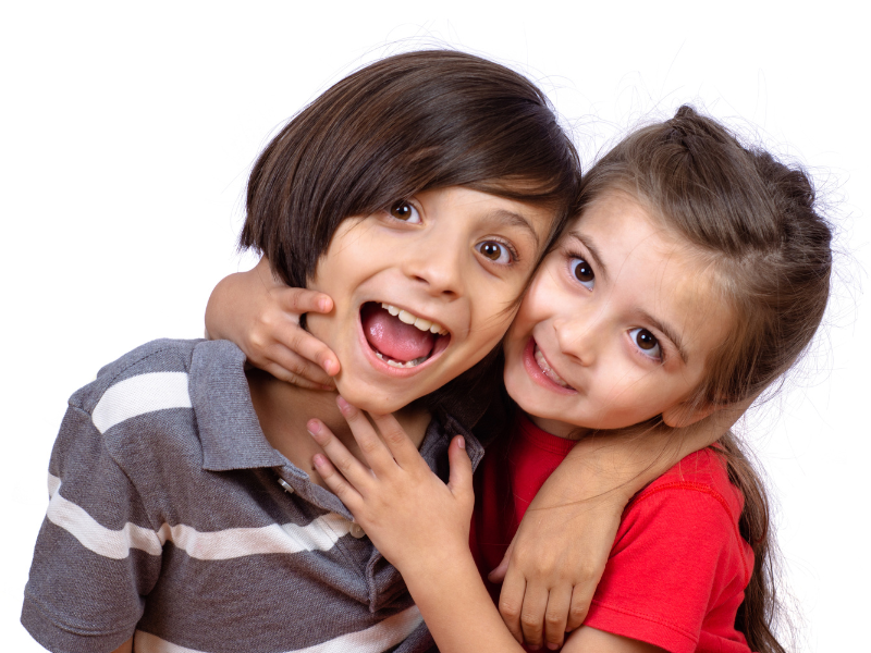 A boy and a girl are hugging each other and smiling.