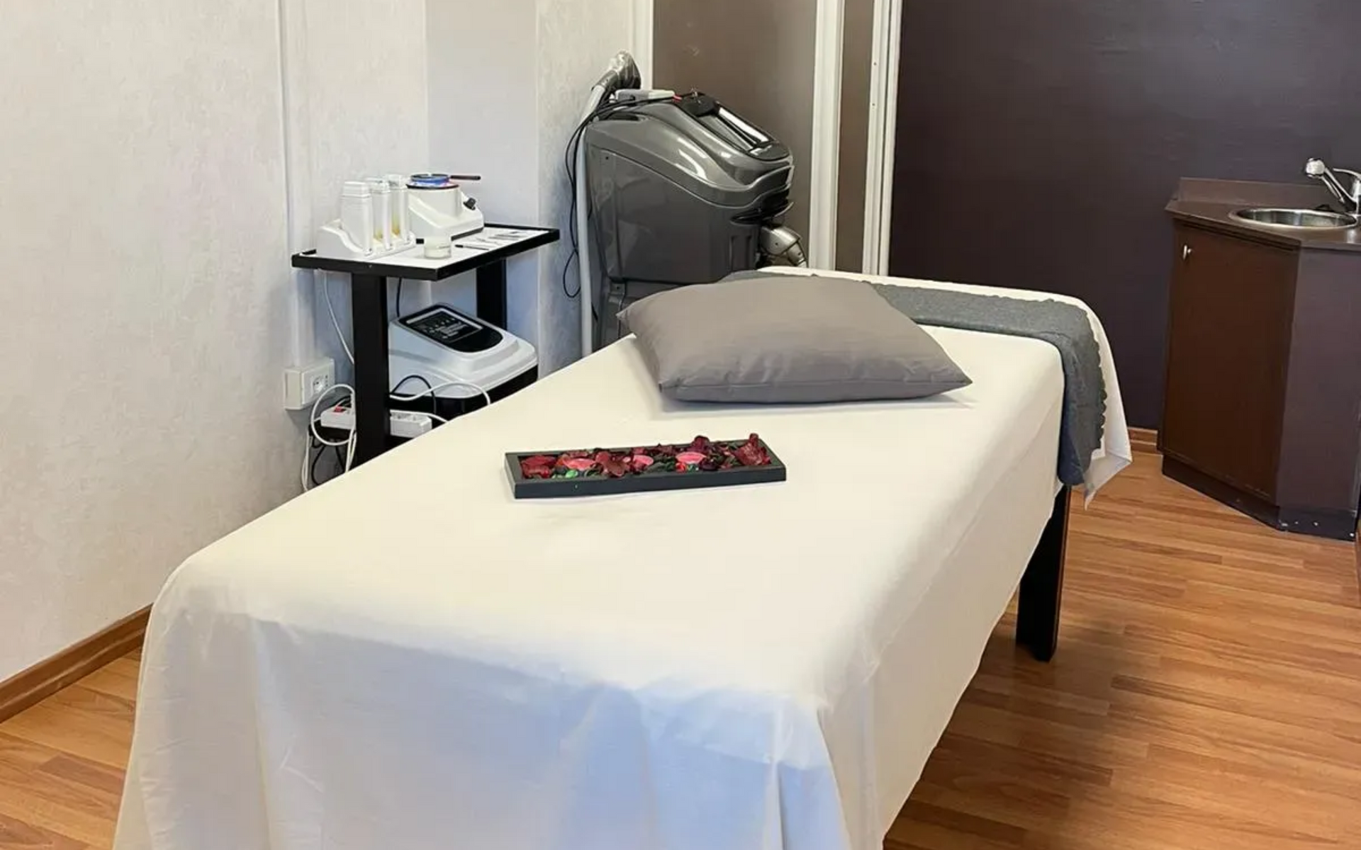 Sala per massaggi terapeutici con lettino, attrezzatura e cuscino.