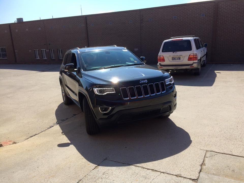A Black Jeep Is Parked In Front Of A Brick Building — Rallimax Wheel Repairs & Alignments in Gundagai, NSW