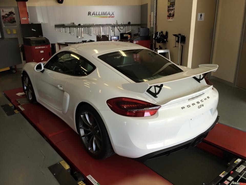 A White Porsche Is On A Lift In A Garage — Rallimax Wheel Repairs & Alignments in Wagga Wagga, NSW